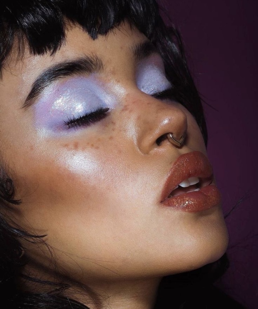 Chica está posando para mostrar su elaborado maquillaje. La protagonista es la sombra morada.